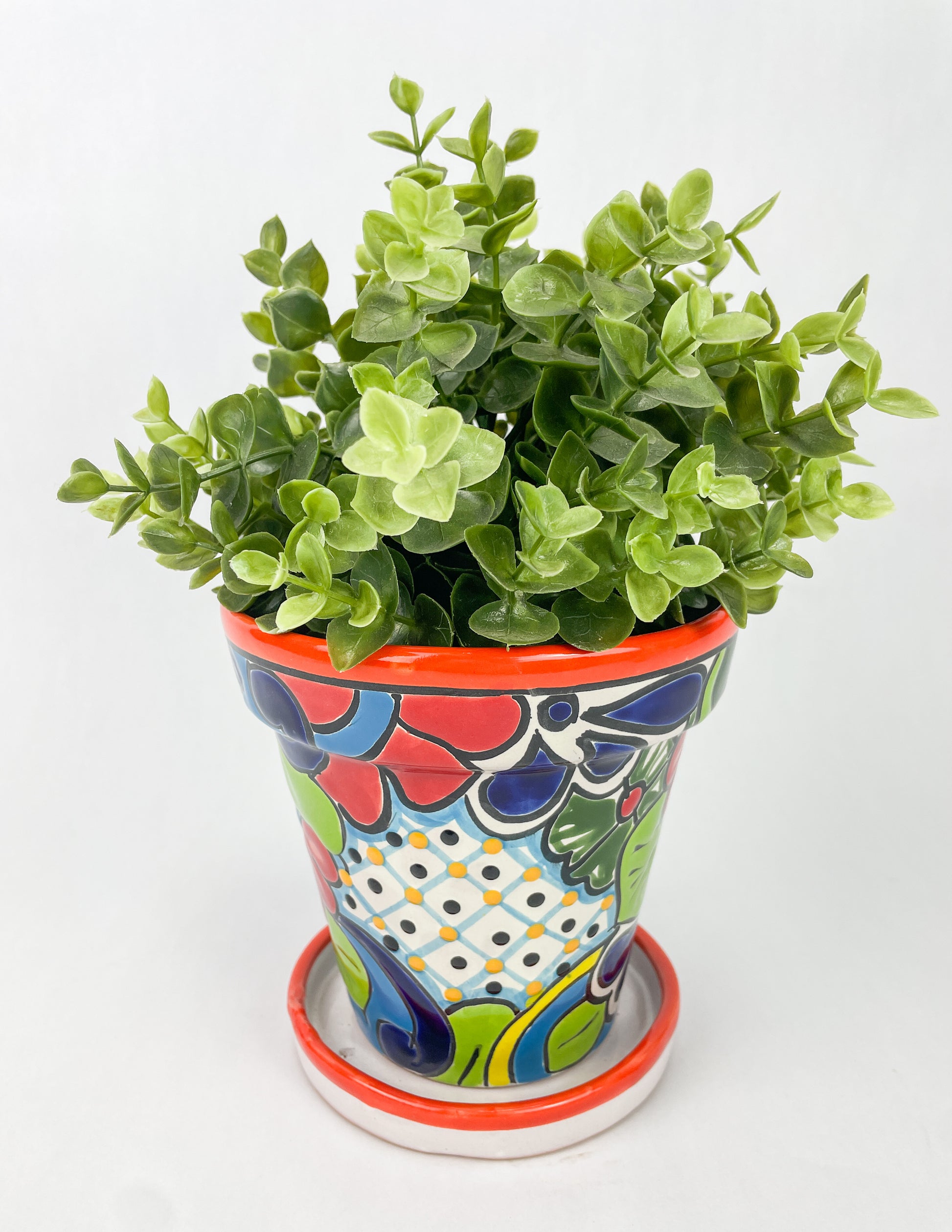 Hand-painted Talavera flower pot featuring vibrant floral design, part of authentic Mexican pottery collection. Talavera planters showcase traditional folk art on rustic furniture. Talavera tile adorns walls alongside Talavera animals in rich colors