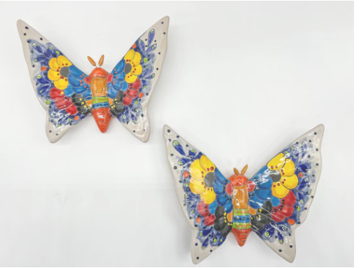 Colorful Mexican wall decor featuring two butterfly-shaped designs.